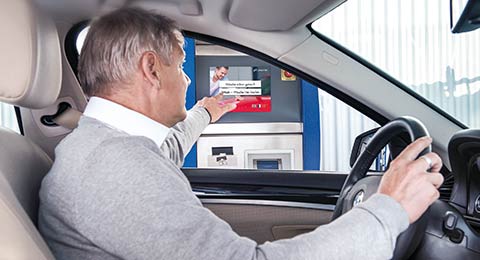 Mann im Auto berührt Touchscreen am Bedienterminal